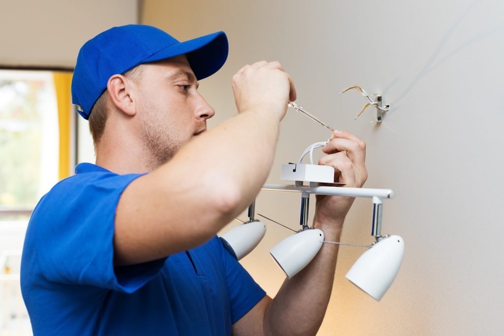 Profissional instalando luminária em residência