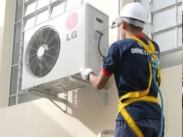 Técnico fazendo manutenção em unidade condensadora de ar-condicionado